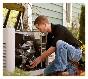 Technician servicing the engine of a Generac home standby generator